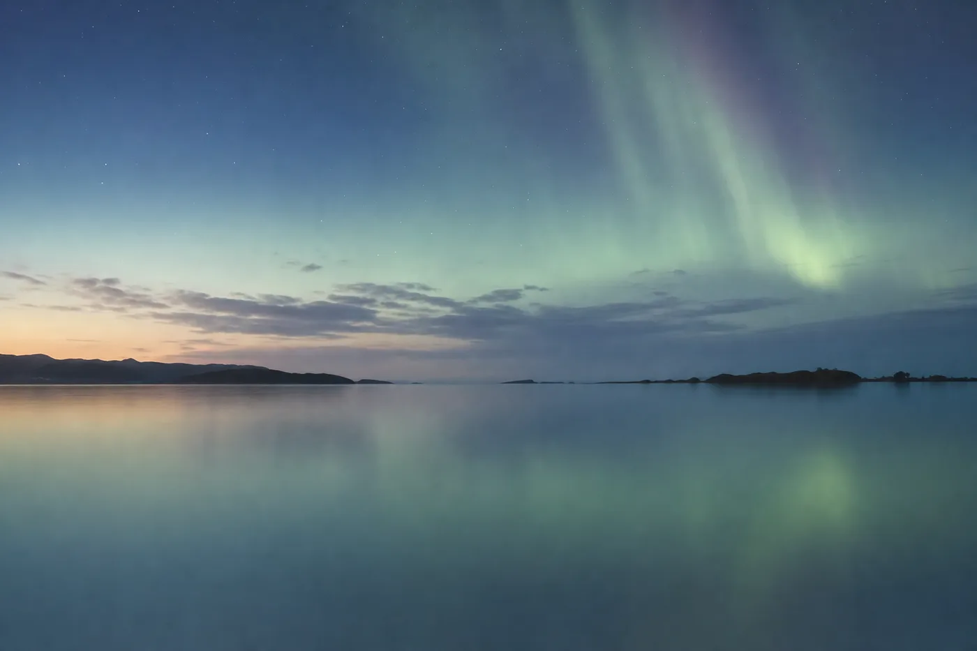 A soft aurora over a calm horizon — the Earth's own resonance